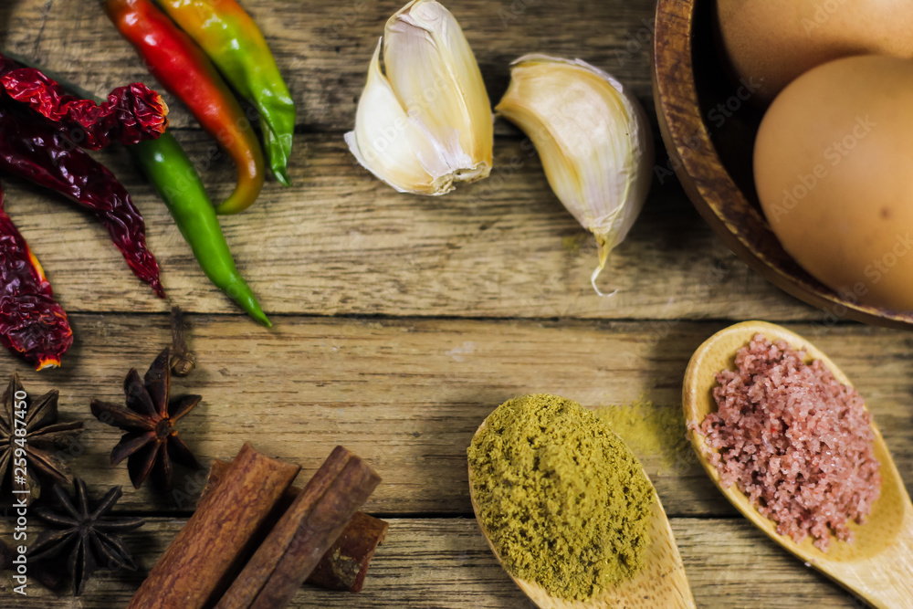Close up of various asian spices and common ingredients on wooden board.