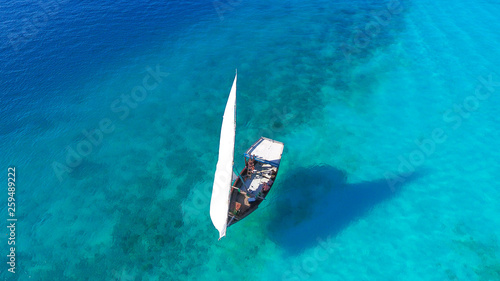 White sailboat in a sea of traditional Dhow Zanzibar island Nungwi Beach. Aerial view © margo1778
