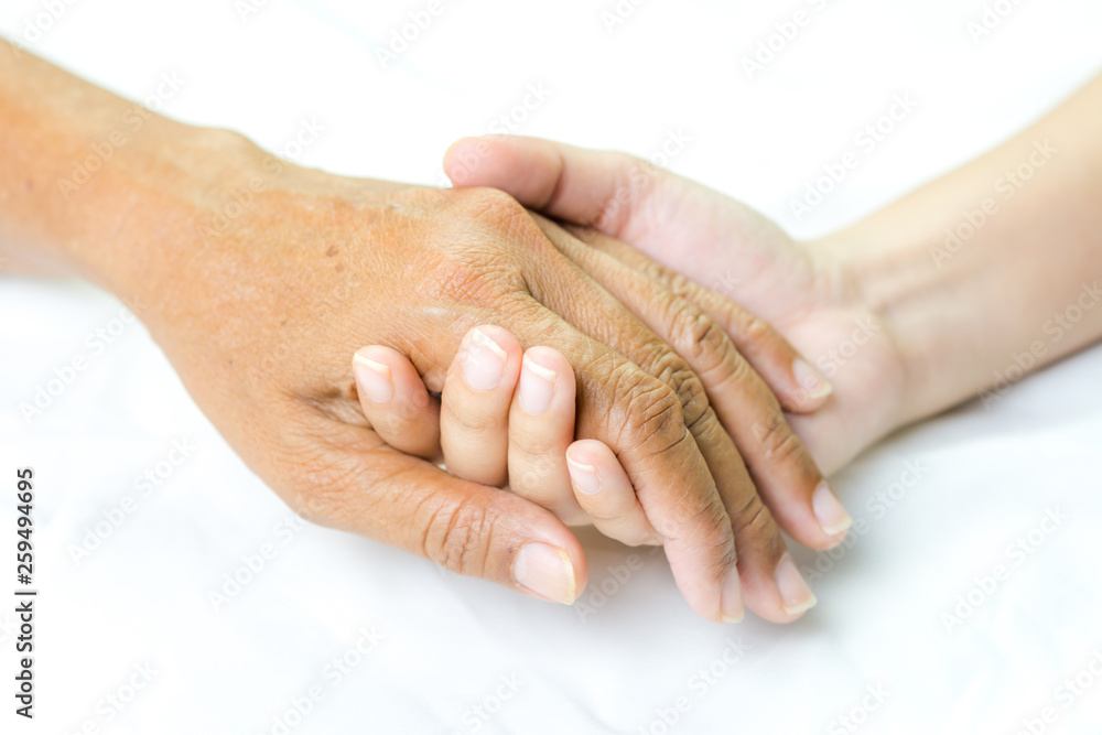 Asian senior and asian young holding hands.