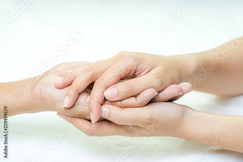Asian senior and asian young holding hands.