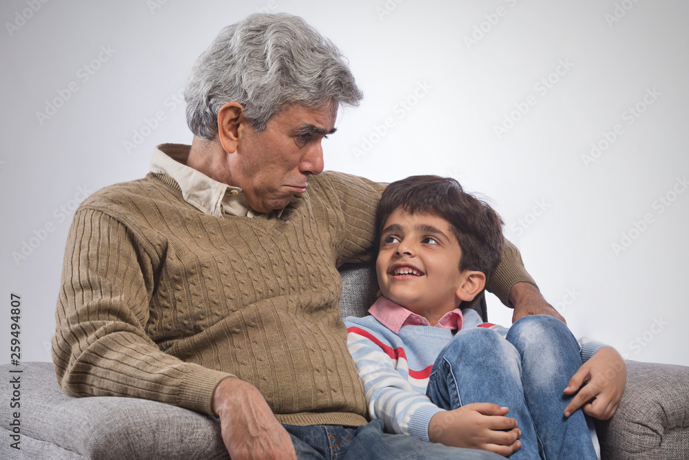 Portrait of grandfather and grandson sitting on sofa Portrait of grandfather and grandson sitting on sofa
