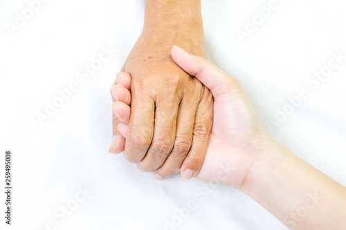 Asian senior and asian young holding hands.