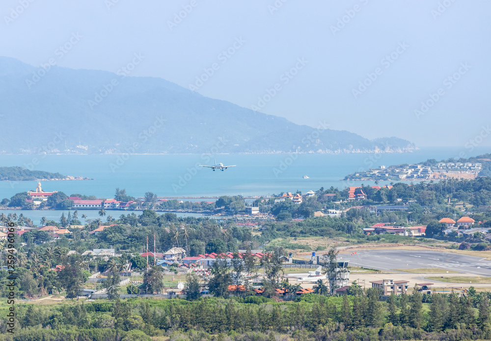White commercial airplane flying take off from runway at Samui Airport, Samui island, Surat Thani, Thailand travel destinations concept. White commercial airplane flying take off from runway at Samui Airport, Samui island, Surat Thani, Thailand travel destinations concept.