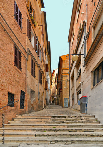 Fototapeta Naklejka Na Ścianę i Meble -  Stone path on streets in Historical center of Macerata with people, old buildings and architecture, Marche, Italy