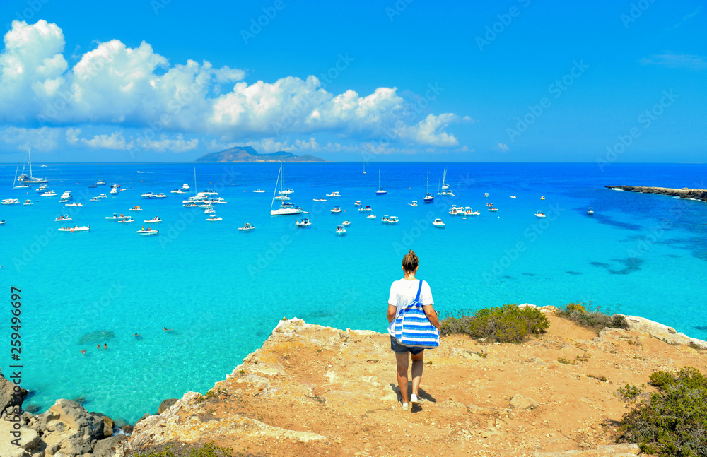 beach Cala Rossa on Favignana Island with small boats and Island Marettimo in background, Sicily Italy