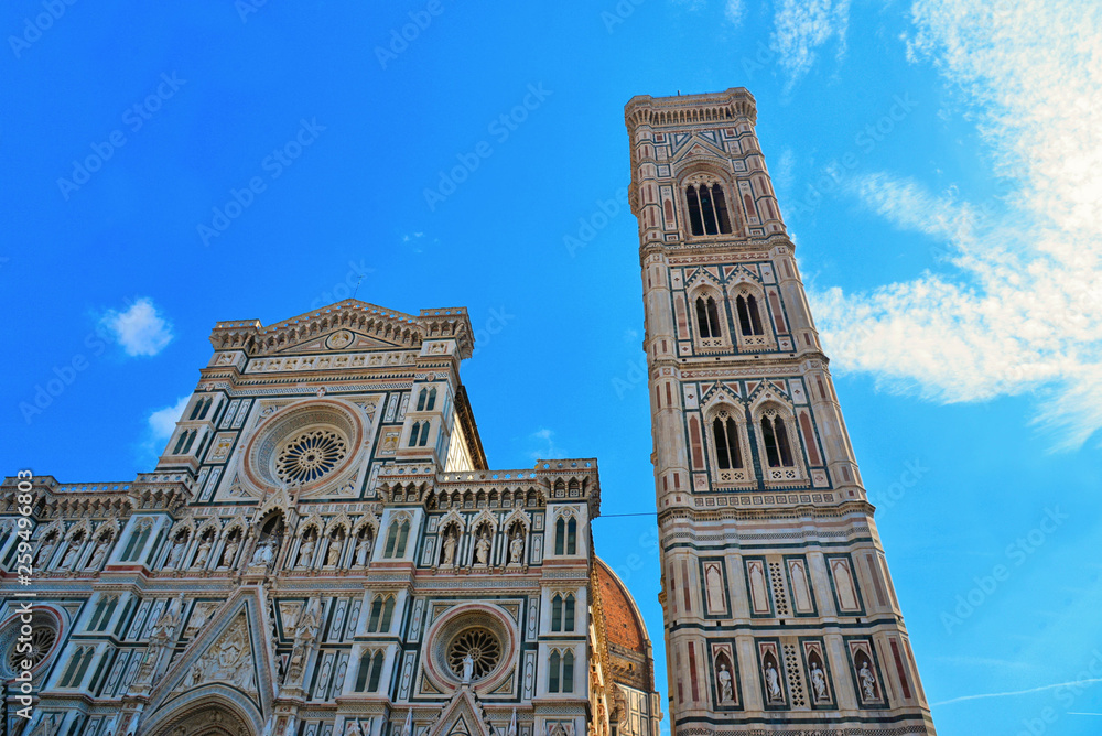 Florence Italy, View on details of the façade of the Santa Maria del Fiore Cathedral with the Giotto's bell tower against cloudy blue sky. Tuscany   