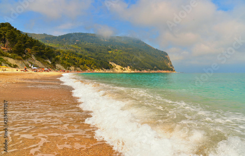 seascape and natural landscape view on empty beach with cloudy blue sky in Sirolo Conero, Marche Italy