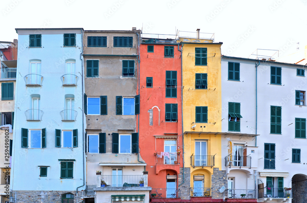 Picturesque panorama with colorful houses with windows and balcony against blue sky in Porto Venere, Italy, Liguria