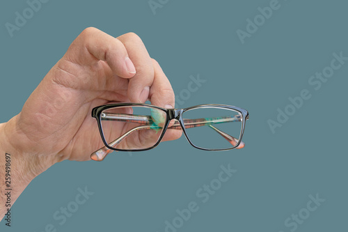 Eye Glasses hand holding isolated close on green pastel background