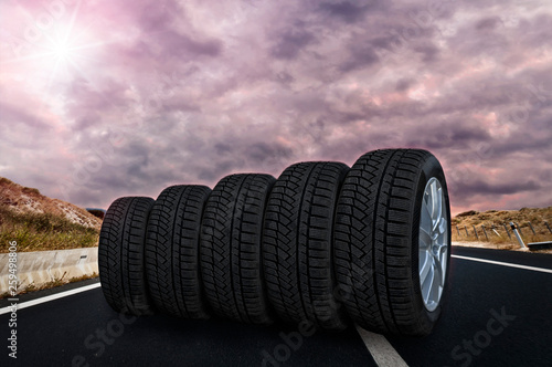 Five tires rolling on a street with purple sky © bennian_1