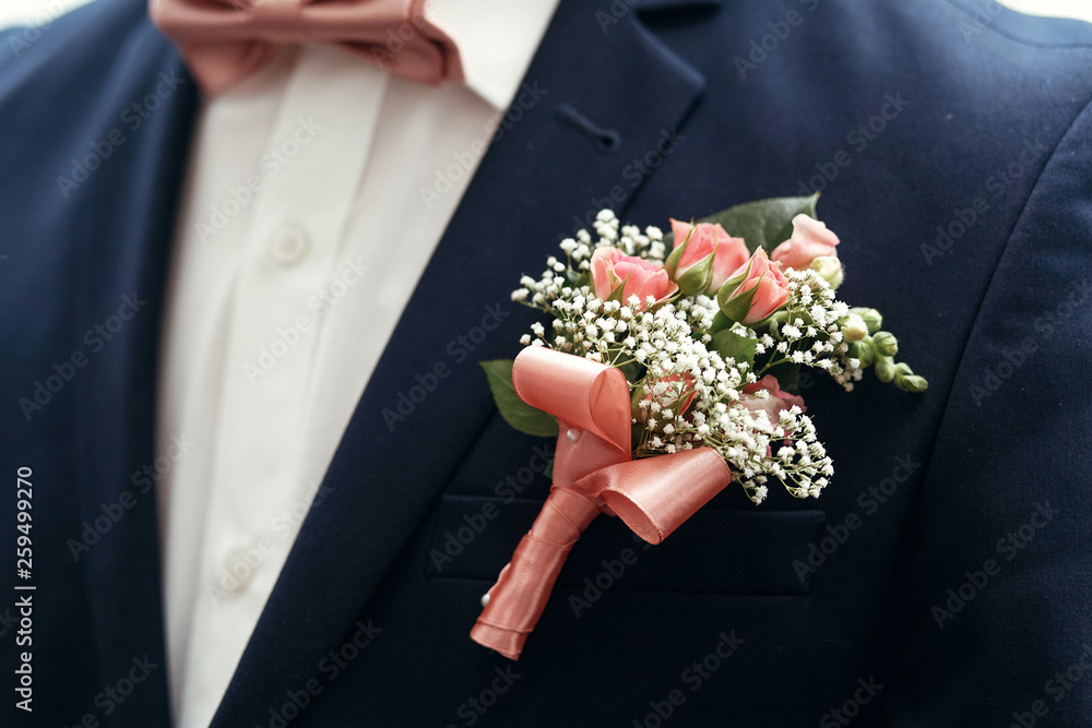 stylish groom or groomsmen in suit with pink roses boutonniere and bow tie posing, getting ready in morning for wedding ceremony. stylish groom or groomsmen in suit with pink roses boutonniere and bow tie posing, getting ready in morning for wedding ceremony.