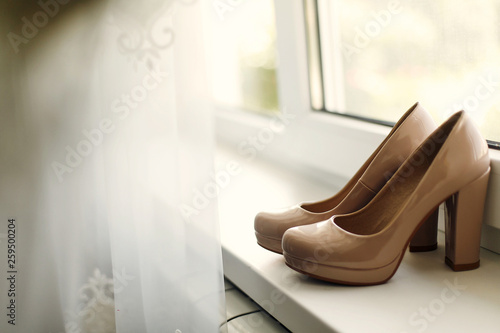 beautiful beige shoes on the window in the morning, bridal morning, wedding preparation.