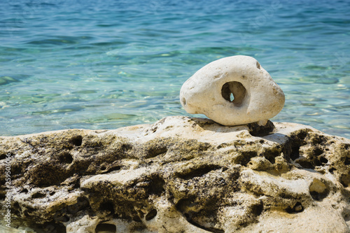 Clear sea and big stone in shape of eye. Wildlife Wunderlast Summer Background. Unusual stone like amulet. Summer background. photo