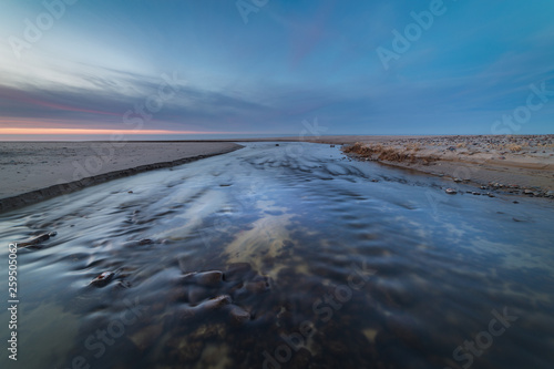Wide and shallow stream on the shore of the Baltic sea at sunset © nuclear_xonix