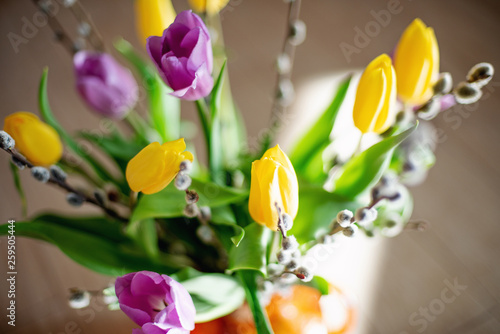 Bright spring bouquet of yellow and purple tulips and branches pussy willows. Easter arrangement of fresh flowers.
