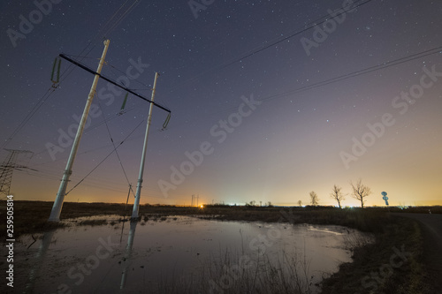 Power line towers at night. Starry sky on the background