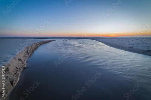 Fototapeta Naklejka Na Ścianę i Meble -  Small river on the sea beach