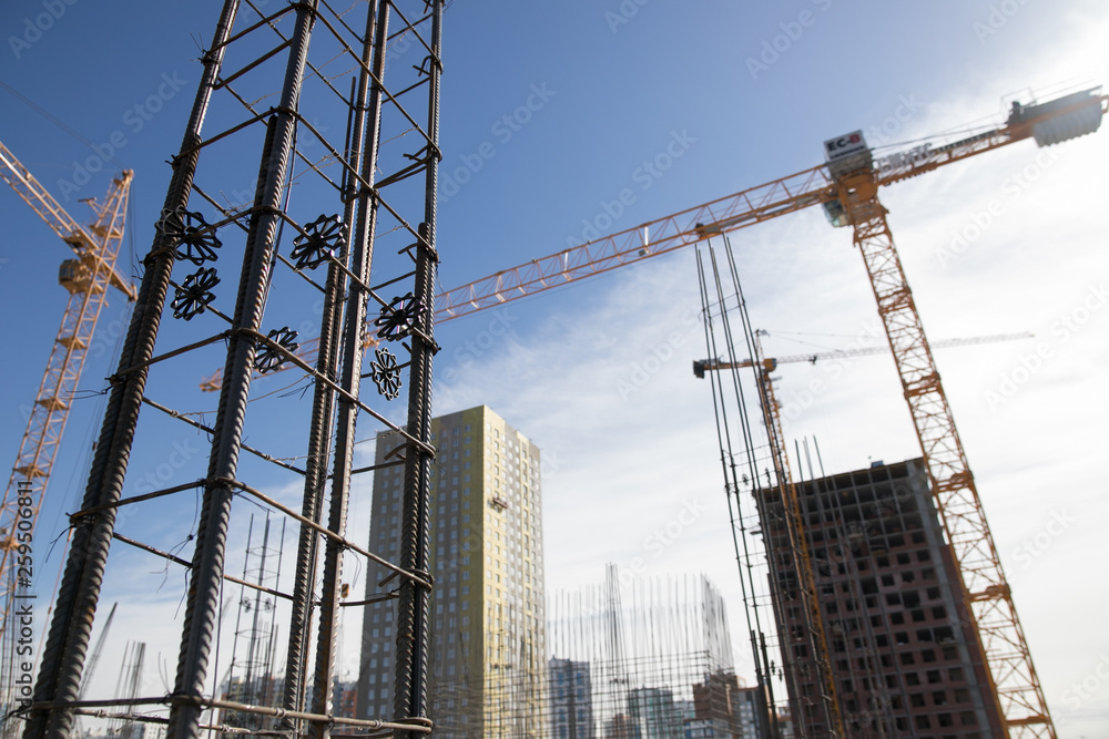 Concrete pillars on construction site. Building of skyscraper with crane, tools and reinforced steel bars. Concrete pillars on construction site. Building of skyscraper with crane, tools and reinforced steel bars.
