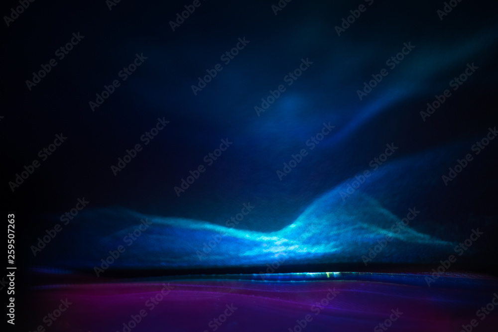 Blurred blue lights on dark background. Defocused lens flare glow.