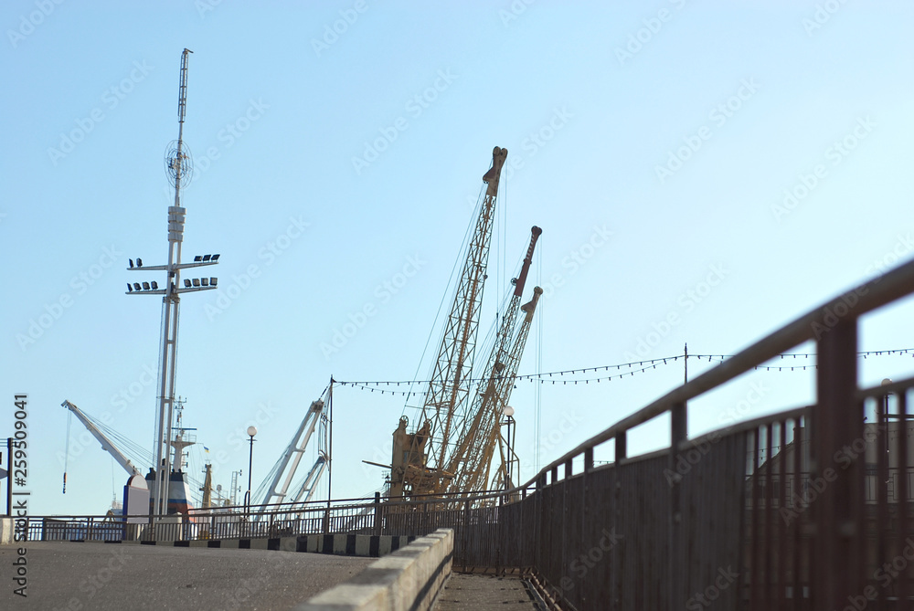 Odessa seaport, Odessa, Ukraine. Cranes and ships in the port against a background of blue sky.