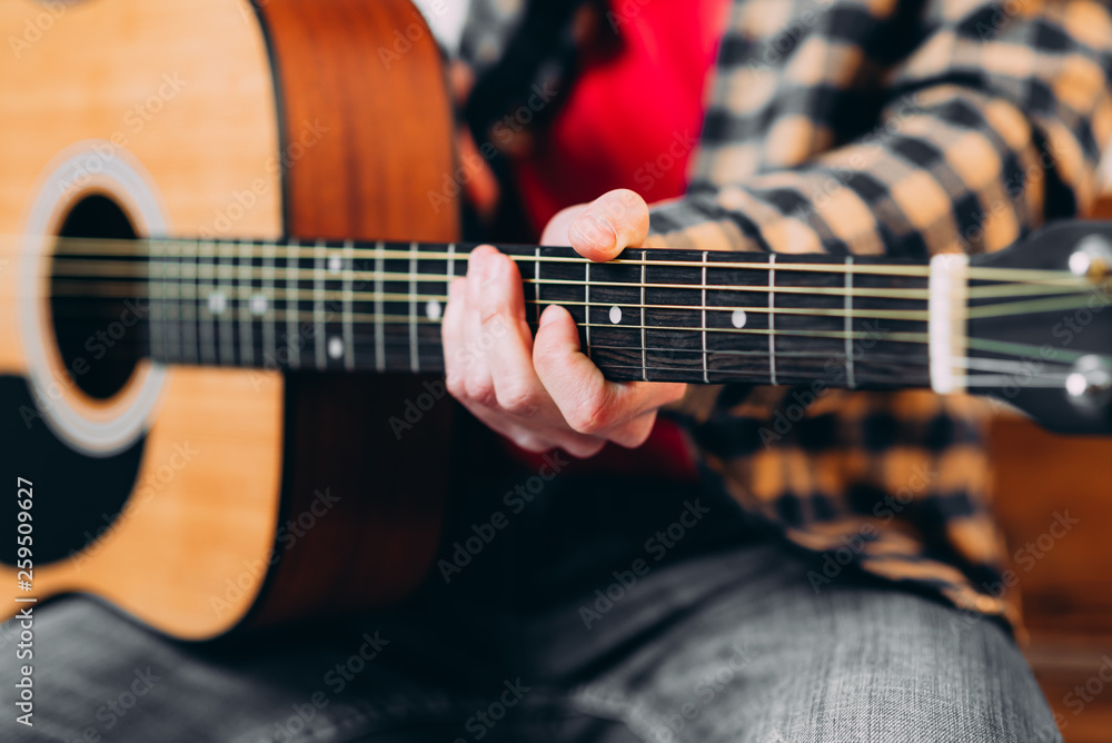 Guitar player. Selective focus of male fingers touching strings while playing the guitar