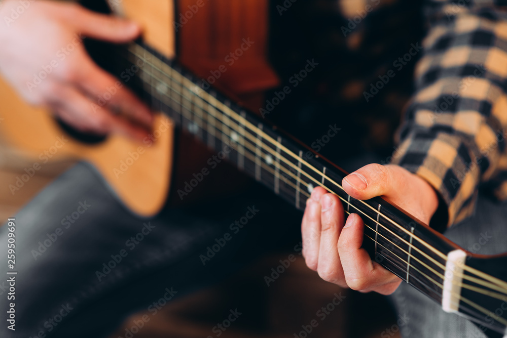 Guitar player. Selective focus of male fingers touching strings while playing the guitar
