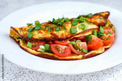 Omelette with cherry tomatoes, toasts with cream cheese and greenery
