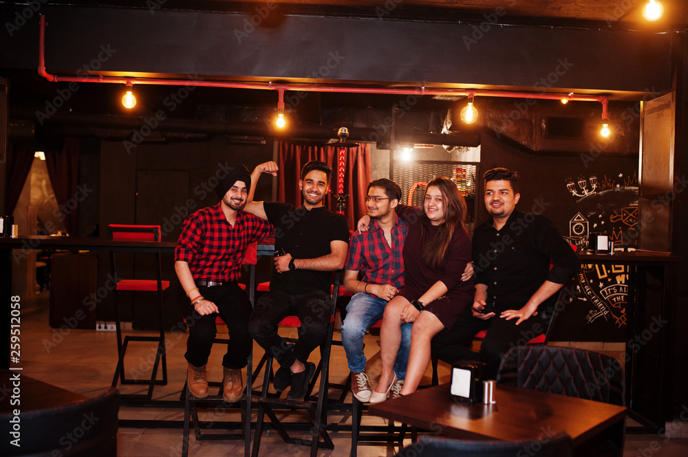 Group of indian friends sitting at lounge bar, having fun and rest.