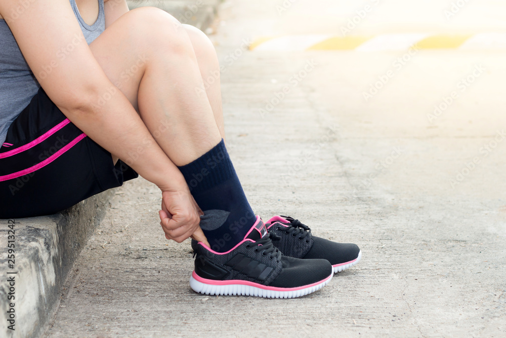 Naklejka premium Young asian athlete woman tying running shoes,female runner ready for jogging on the road outside,wellness and sport concepts