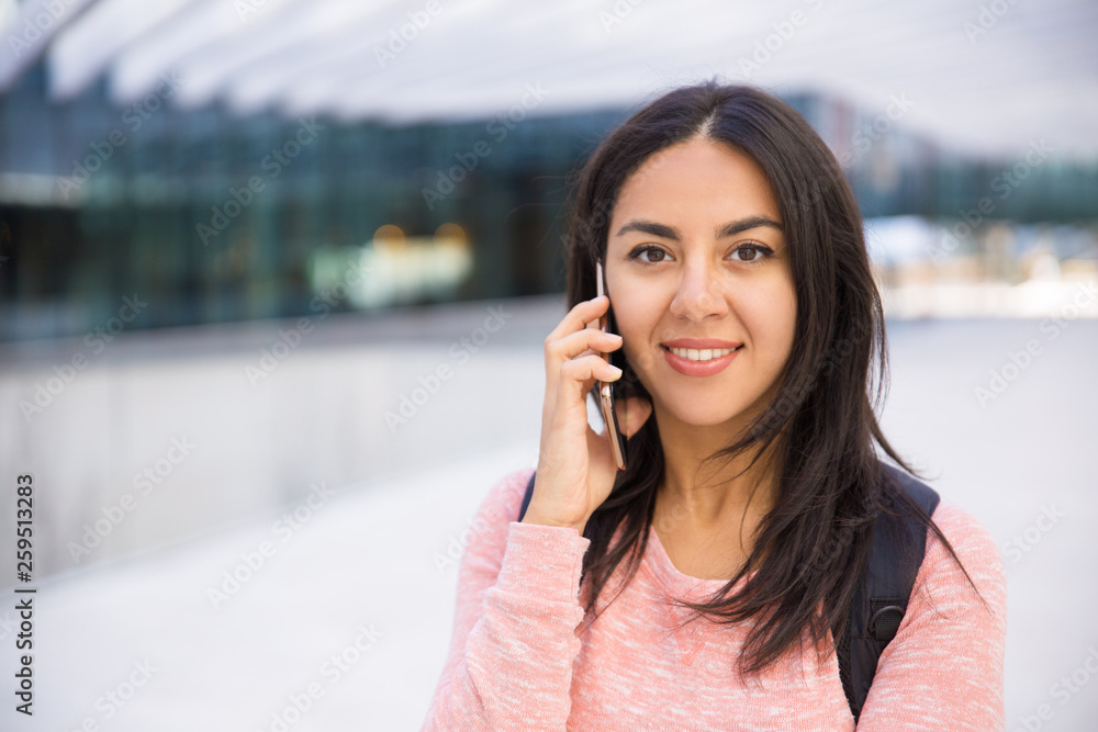 Happy attractive girl talking on cellphone and looking at camera Happy attractive girl talking on cellphone and looking at camera