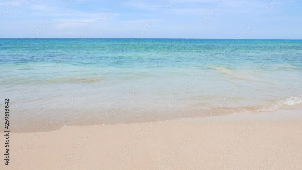 Wave at a beautiful tropical white sand beach with blue sky Wave at a beautiful tropical white sand beach with blue sky