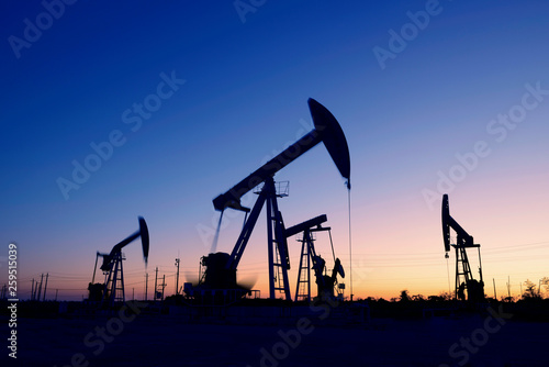 Oil pumps in action, silhouetted against the setting sun