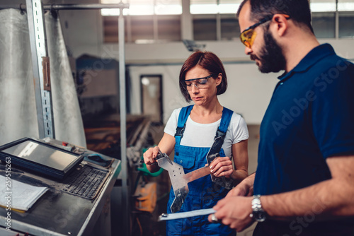 Female supervisor measuring cut out product on CNC machine