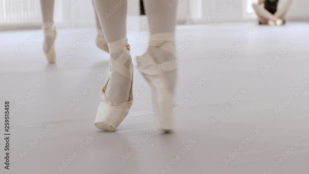 Ballerina's training their pointe techniques in a ballet school, close-up slow motion footage of their pointe shoes. Ballerina's training their pointe techniques in a ballet school, close-up slow motion footage of their pointe shoes.