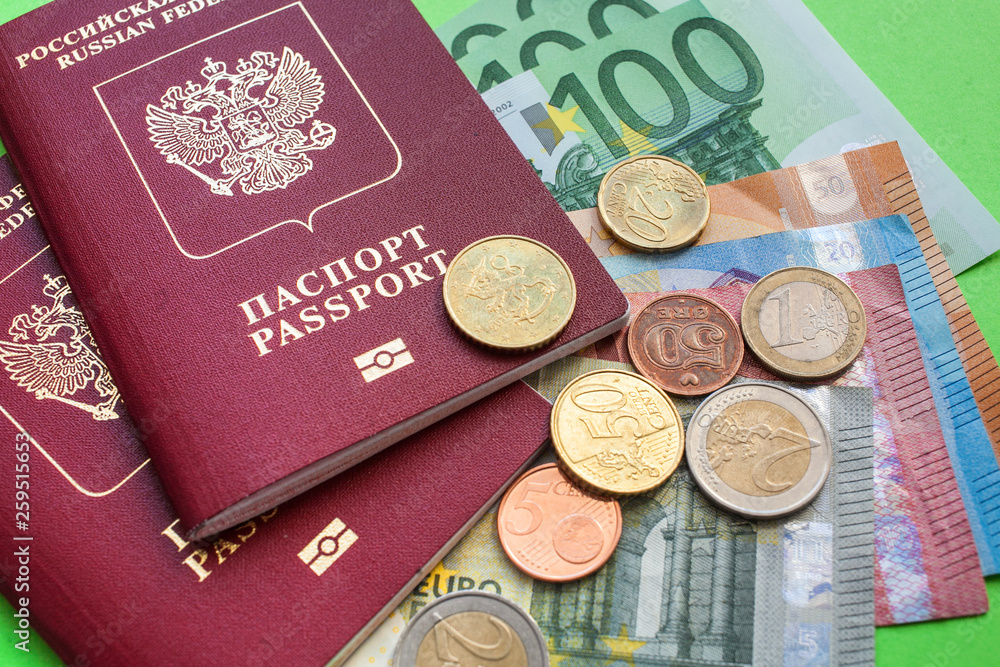 Two Russian foreign passports and euro notes of various denominations and Eurocent on a green background clpse up Two Russian foreign passports and euro notes of various denominations and Eurocent on a green background clpse up