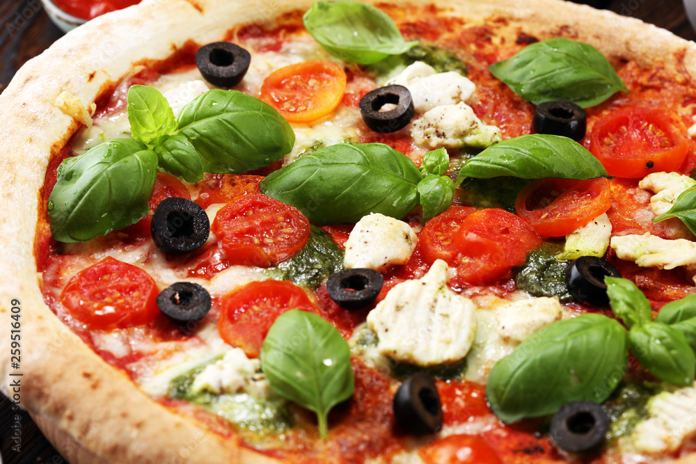 Pizza with tomatoes, mozzarella cheese, black olives and basil. Delicious italian pizza on wooden pizza board. Pizza with tomatoes, mozzarella cheese, black olives and basil. Delicious italian pizza on wooden pizza board.