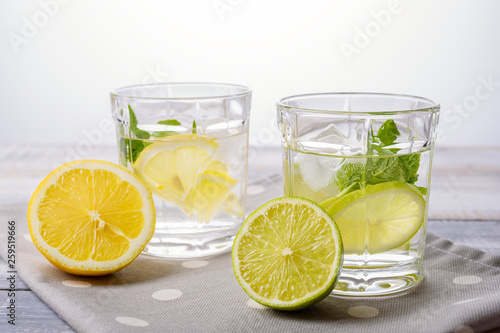 close-up of summer cocktails with lemon, lime and mint on light background