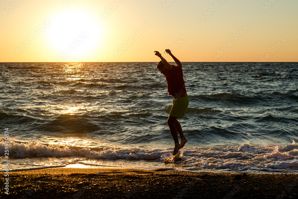 Photo of happy man jumping on seashore