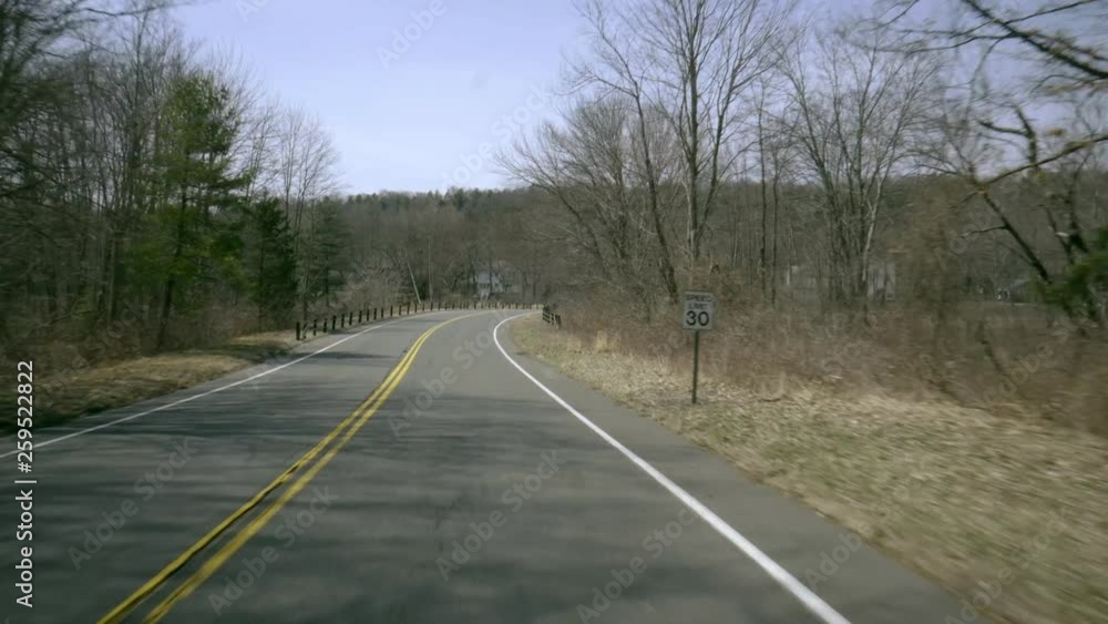 a fast drivers pov from a car windshield down a rural road leading up to a small pond a fast drivers pov from a car windshield down a rural road leading up to a small pond