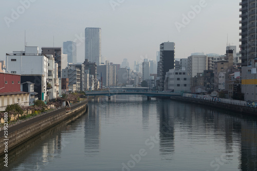 Cityscape with river, bridges and buildings in Osaka in spring clear day