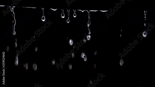 Dripping water (rain) on black background, Slow motion (120 FPS). photo