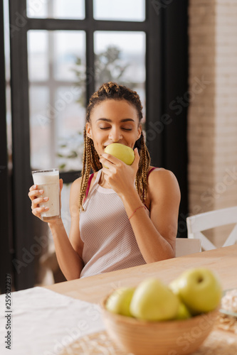 Woman loving apples feeling good while smelling green apple