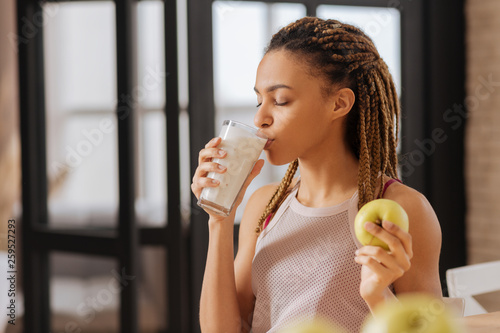 Εκτύπωση καμβά Young woman with little braids drinking glass of milk