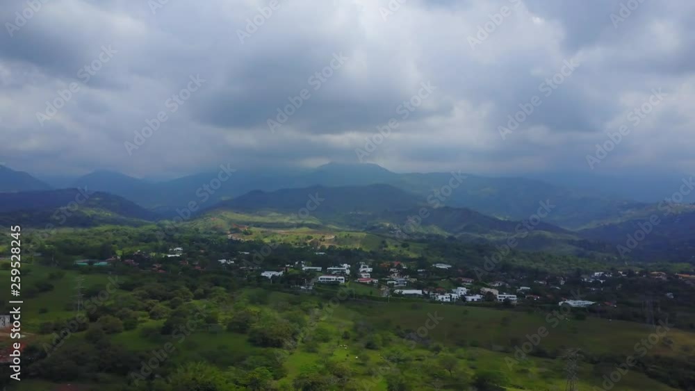 AERIAL: wide diagonal pan across the mountainous terrain found in Cali, Colombia on an overcast day. AERIAL: wide diagonal pan across the mountainous terrain found in Cali, Colombia on an overcast day.
