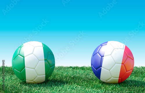Two soccer balls in flags colors on green grass. Nigeria and France. 3d image