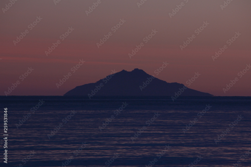 Sunset over Montecristo island from Marina di Campo beach, Elba island, Tuscany, Italy