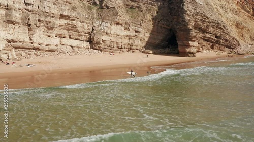 Aerial: Surfers at Sagres during a sunny day.