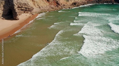 Aerial: Surfers at Sagres during a sunny day.