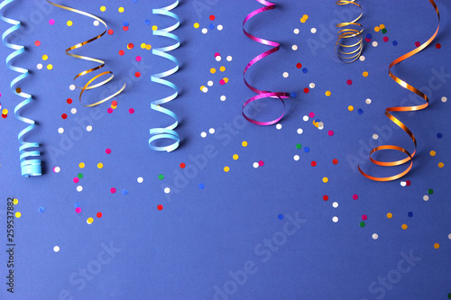  Festive background of ribbons and confetti on a colored background top view. photo