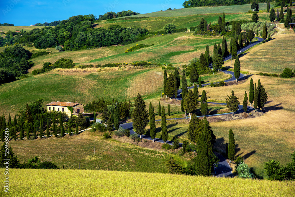 charming landscape with a car on a curved road with many twists in Tuscany, Italy near Pienza. Excellent tourist places.
